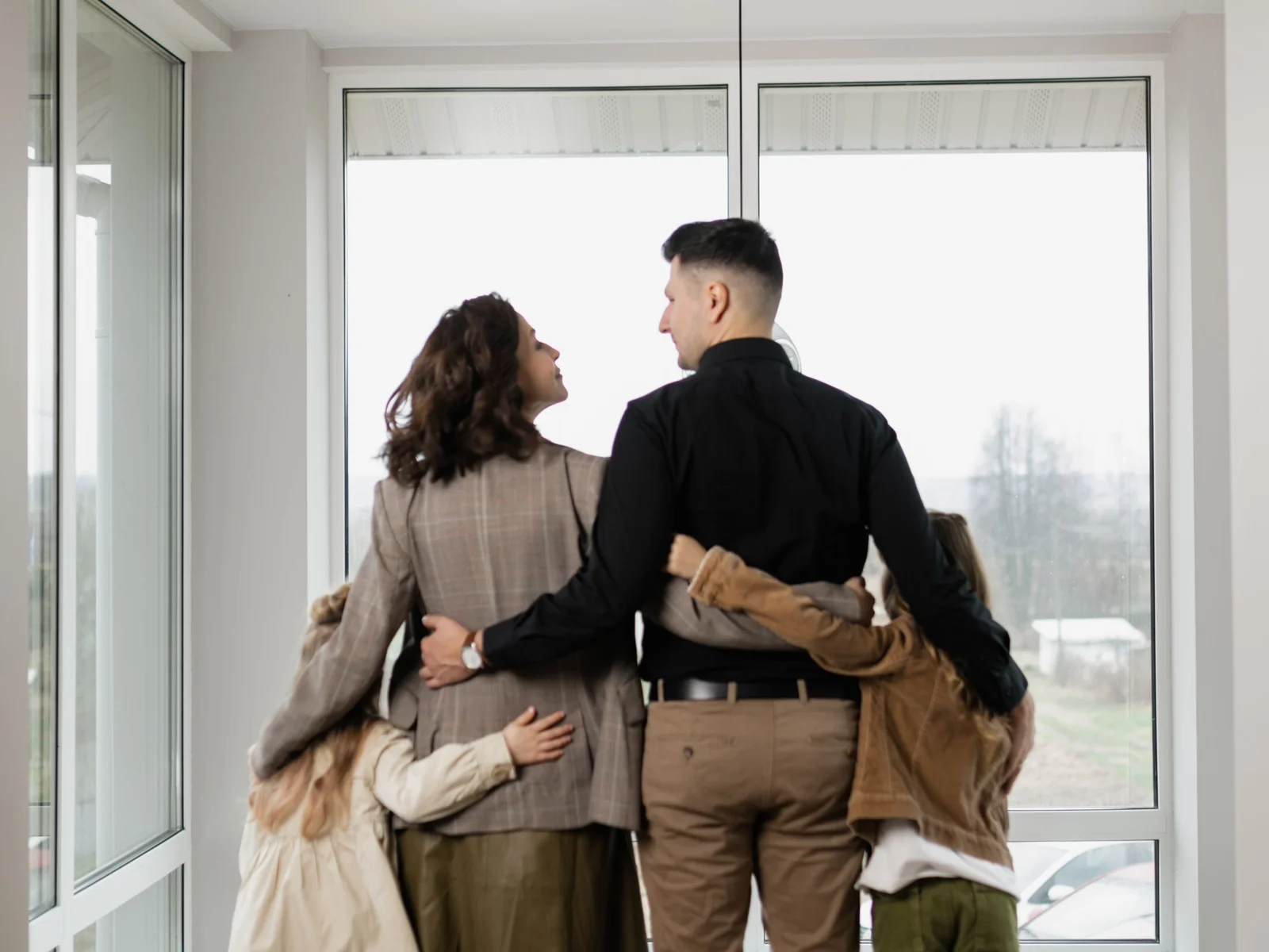 Familie von hinten am Fenster ihres Zuhauses